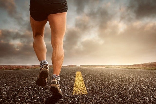 Biegacz na asfaltowej drodze biegnie maraton